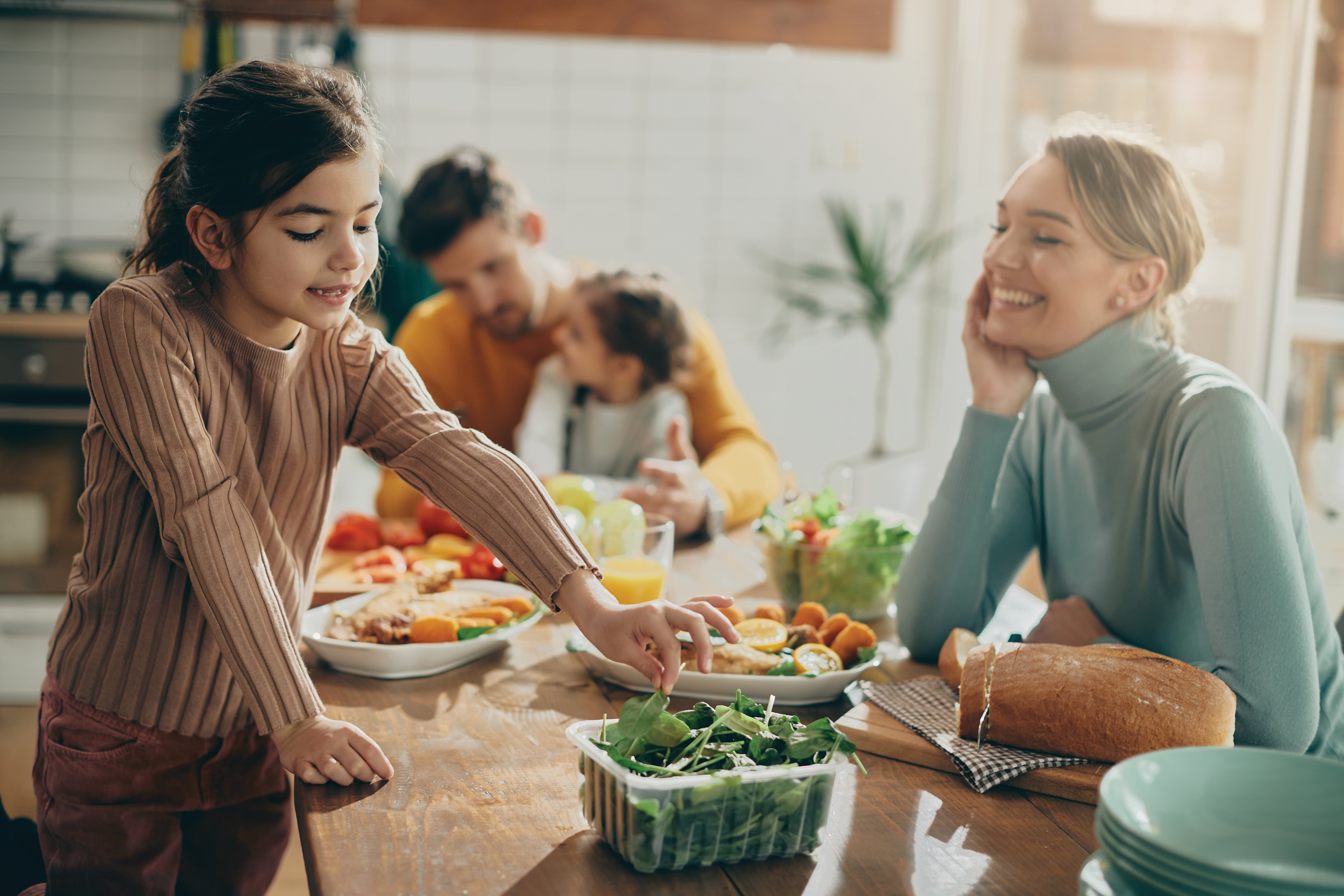 A Family of Four Cooking a Meal Together