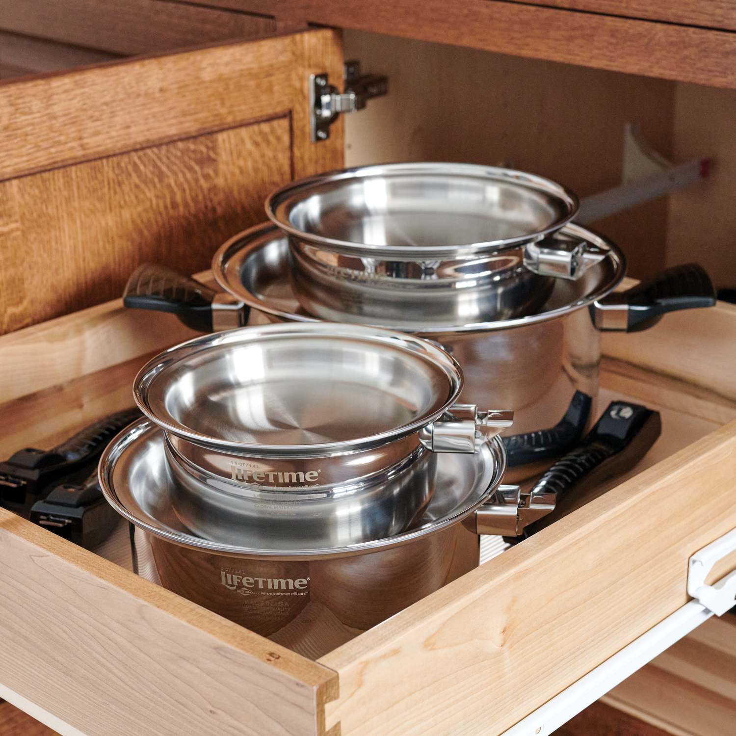 Numerous Lifetime Cookware Pots Being Stored in One Cabinet